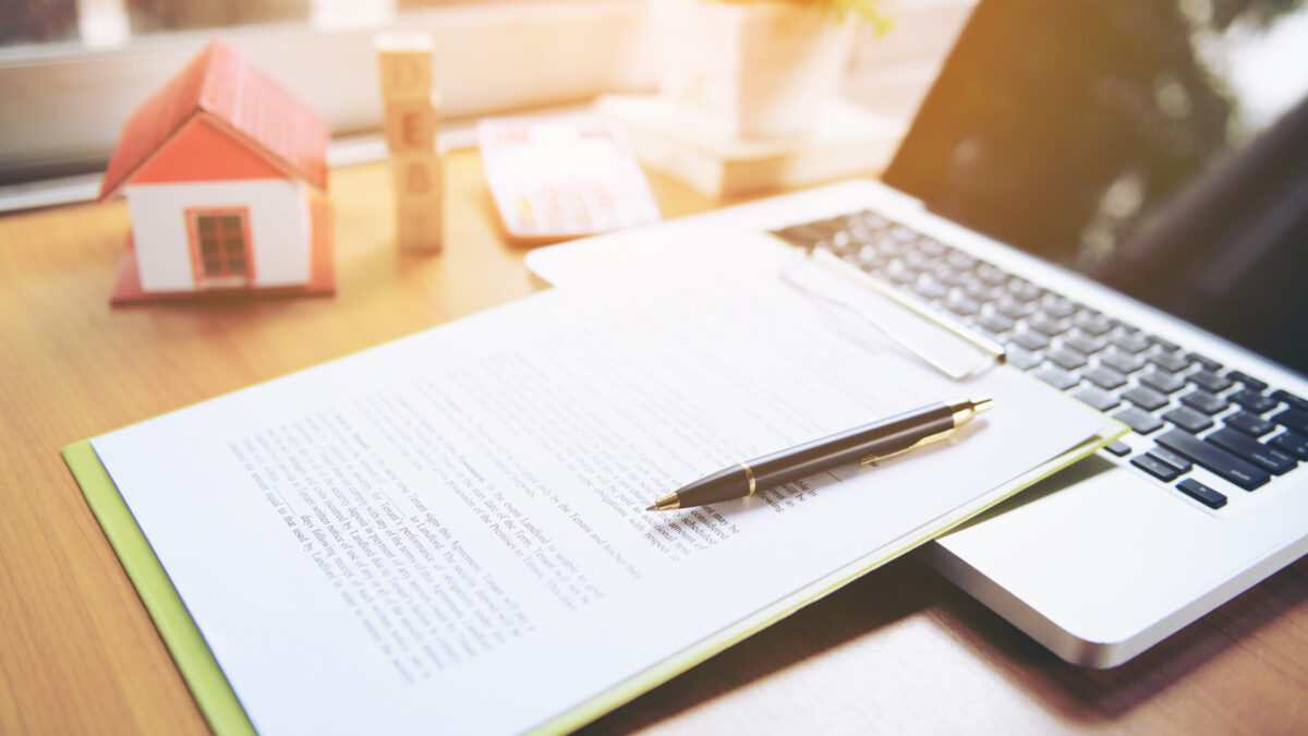 title insurance forms and a laptop on a desk