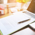 title insurance forms and a laptop on a desk