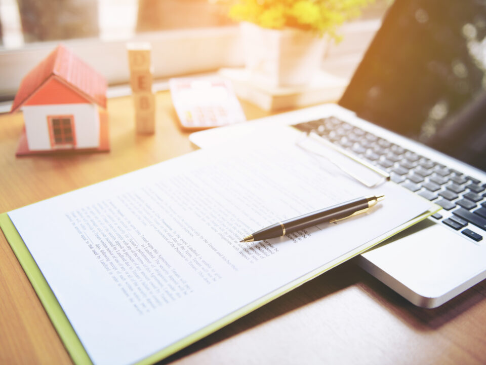 title insurance forms and a laptop on a desk