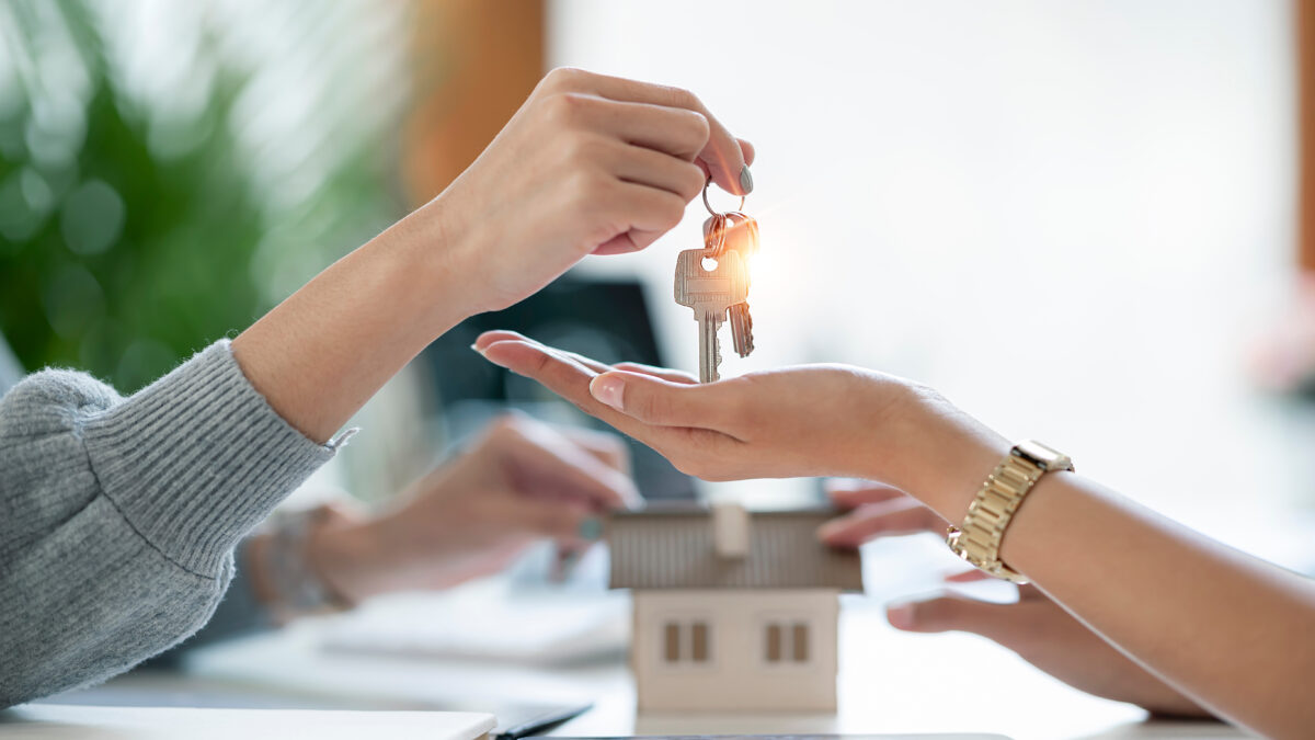 Real estate agent handing keys to her client