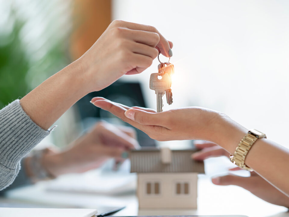 Real estate agent handing keys to her client